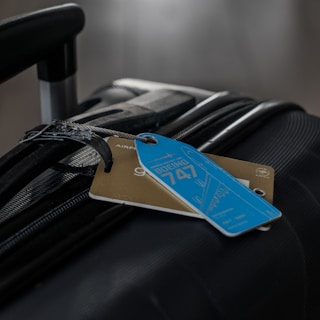 A luggage bag with a blue tag on it
