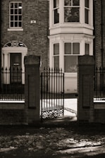 A black and white photo of a building with a gate