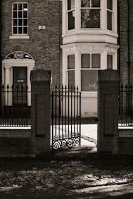 A black and white photo of a building with a gate