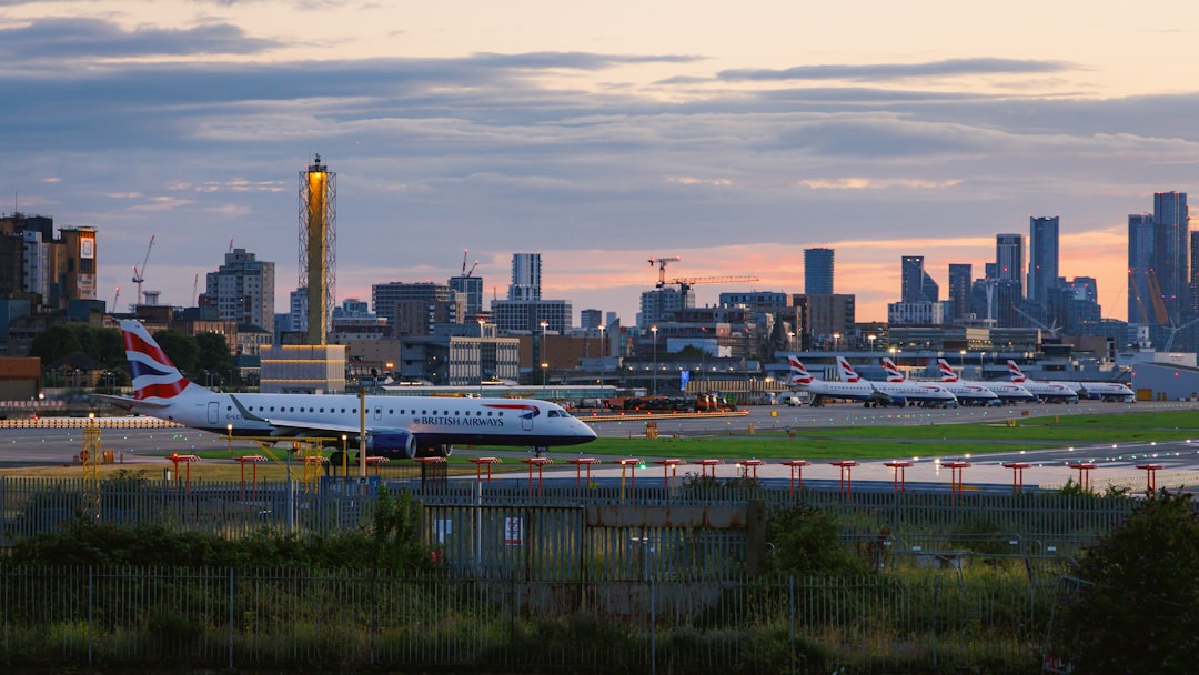 A large jetliner sitting on top of an airport tarmac, A British Airways aircraft lining up to runway at London City Airp