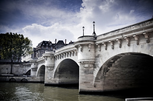 A bridge over a body of water with buildings in the background