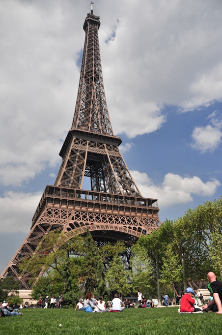 A group of people sitting in front of the eiffel tower