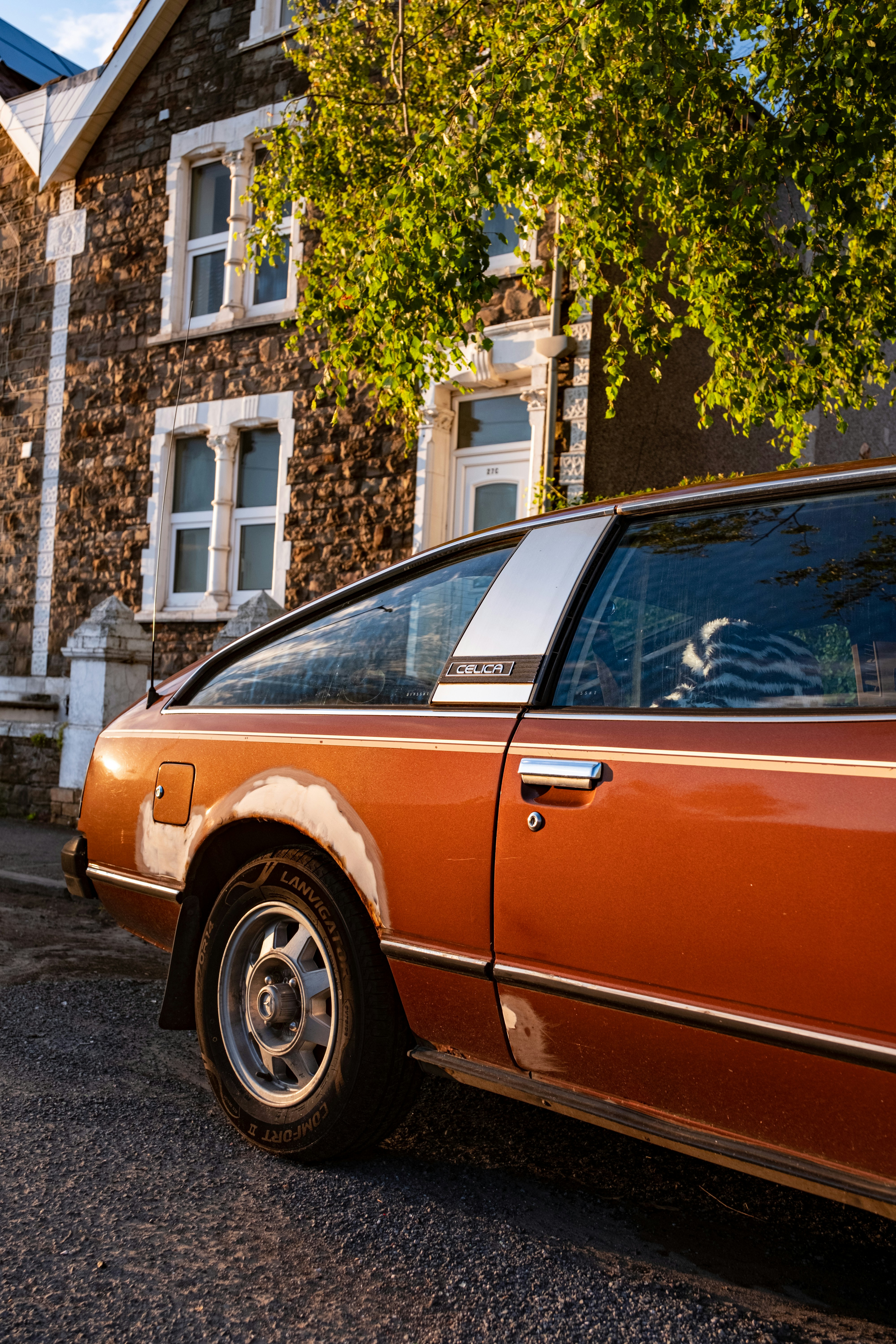Un coche naranja aparcado frente a una casa