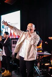 A man standing on a stage singing into a microphone