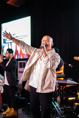 A man standing on a stage singing into a microphone