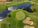 An aerial view of a golf course with a pond