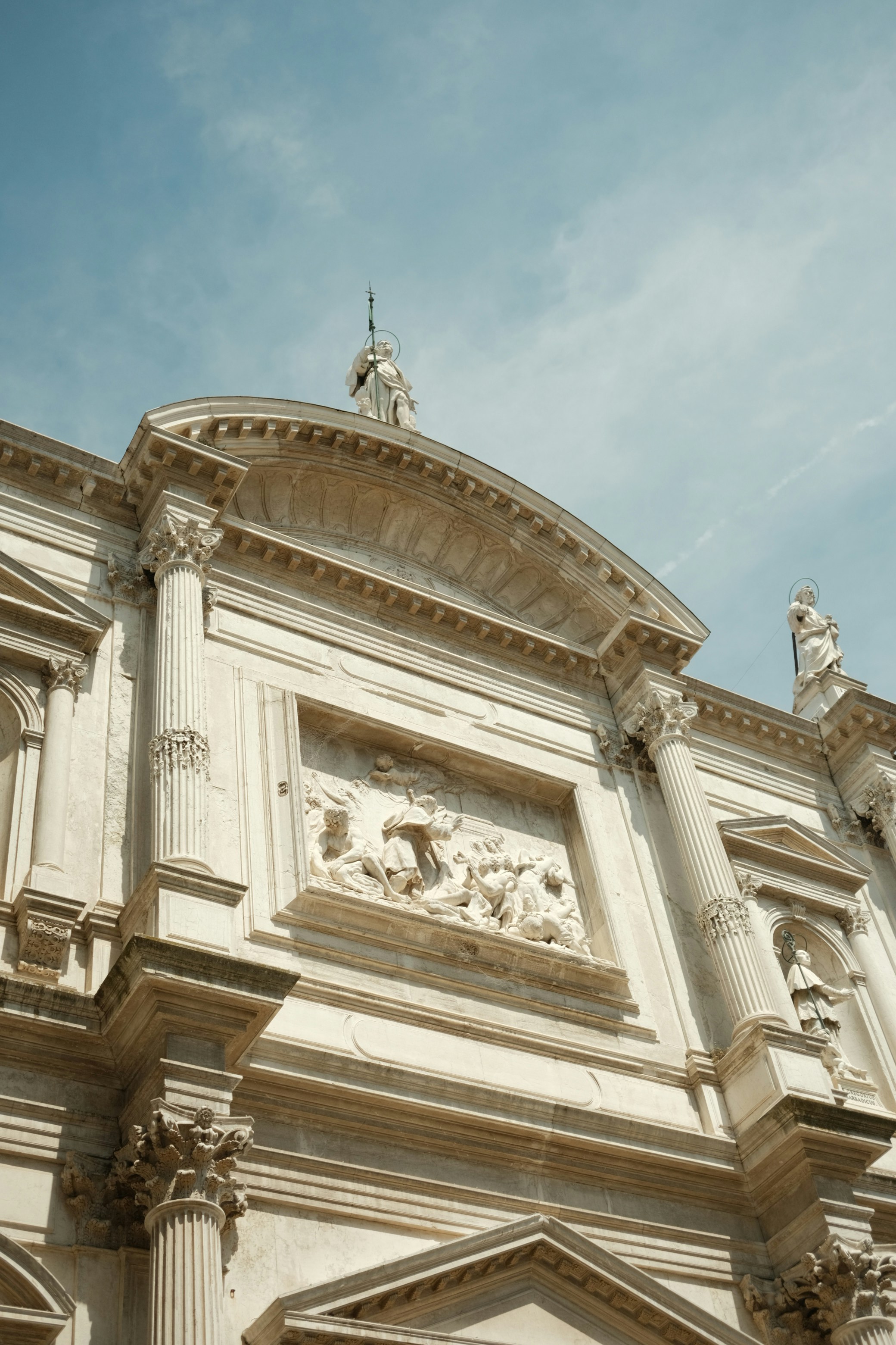 A white building with a clock on the front of it