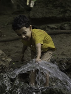 A young boy playing in a stream of water