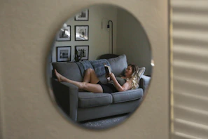 A woman laying on a couch reading a book