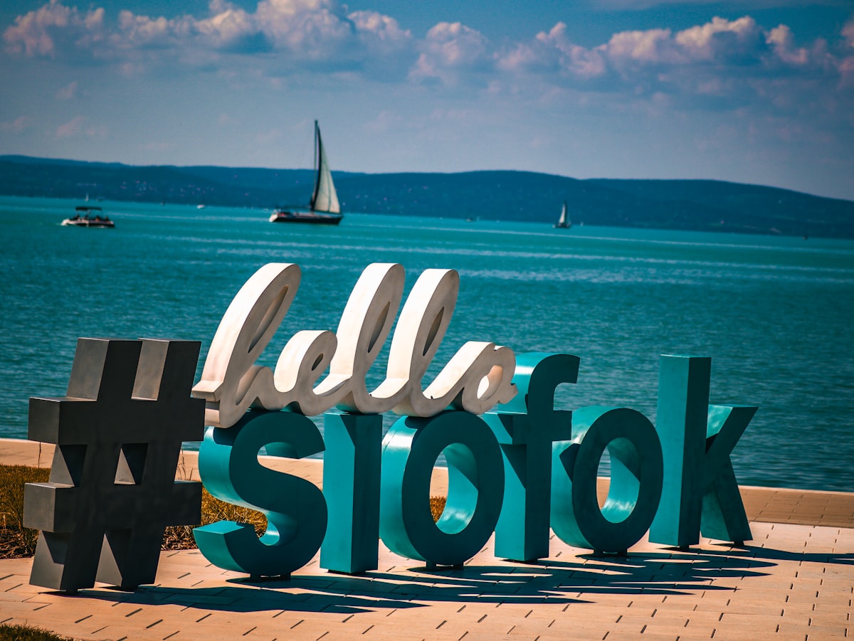 A sign that says hello stofk in front of a body of water