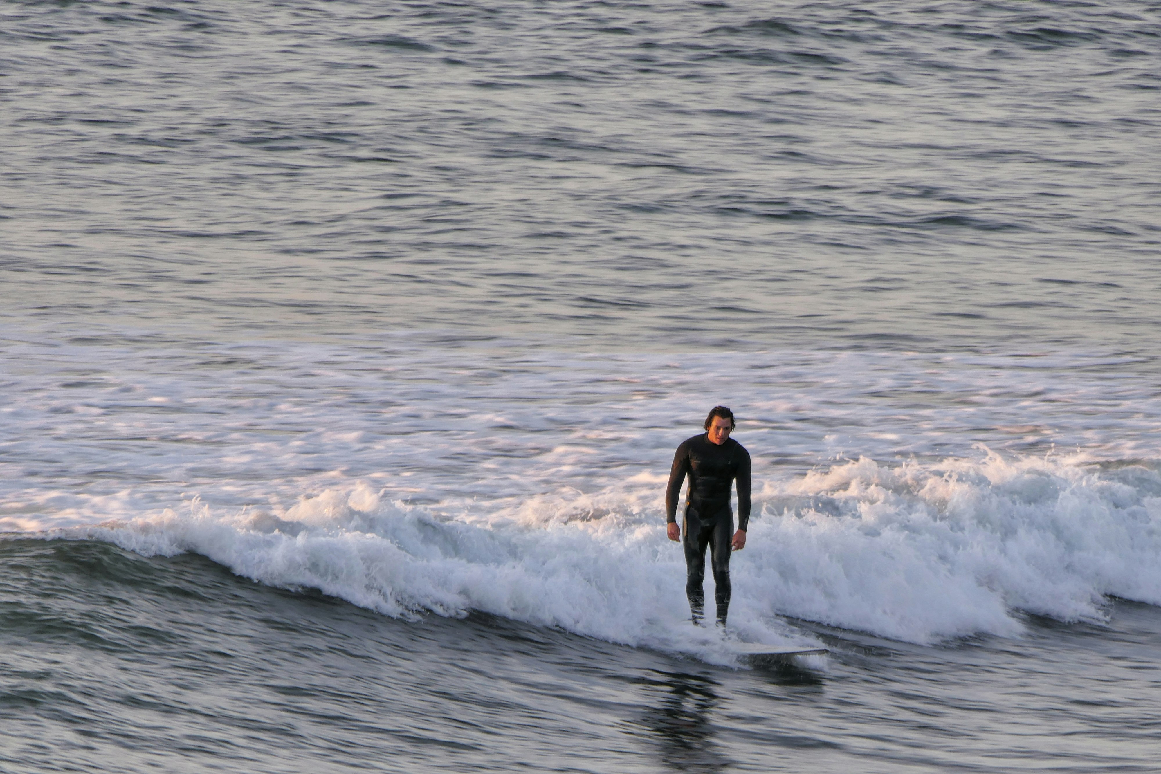 A man riding a wave on top of a surfboard