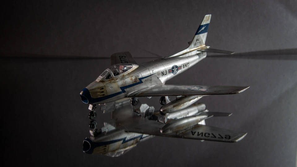 Silver and blue painted model airplane with blue stripe on tail section displayed prominently