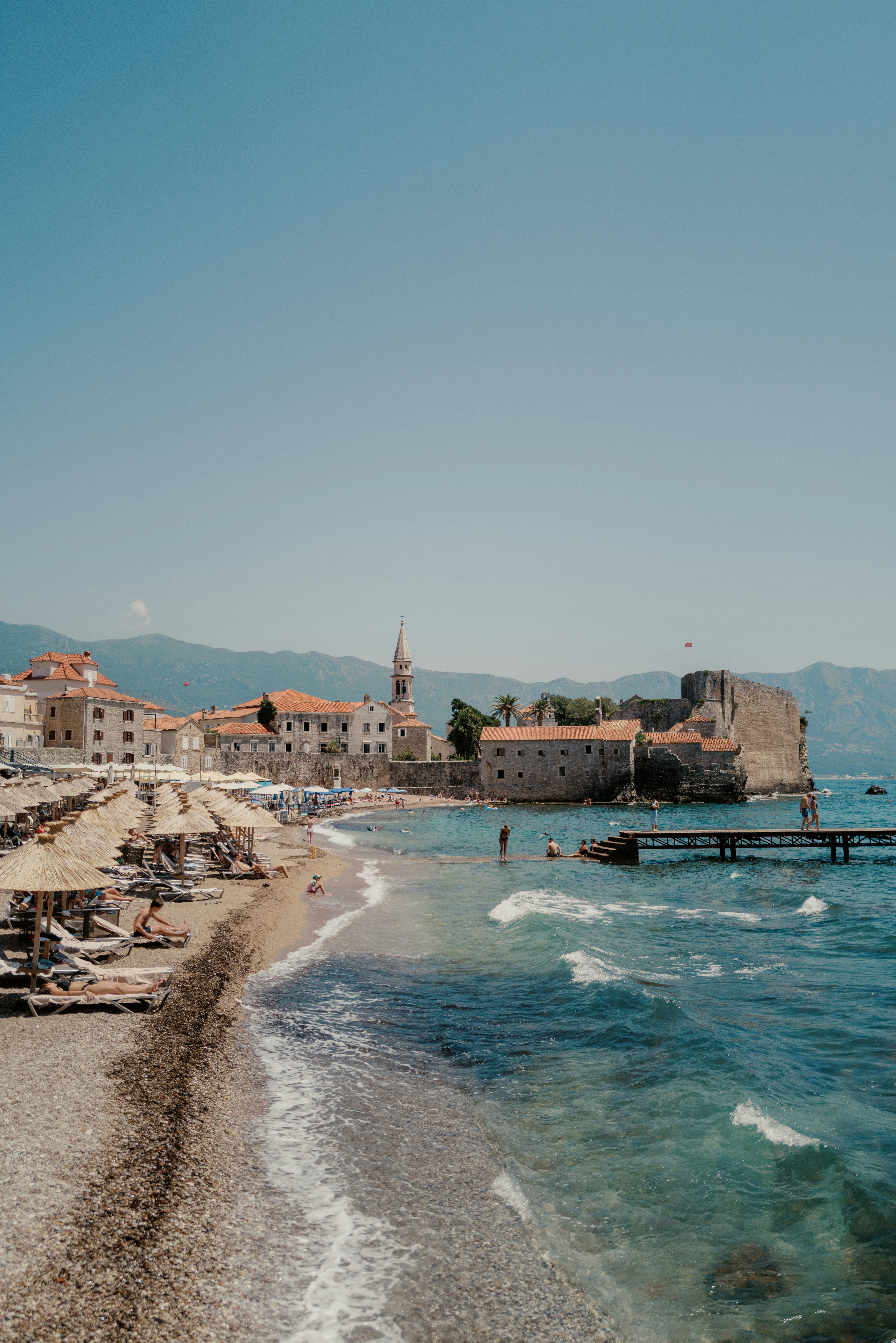 A beach that has a bunch of chairs on it