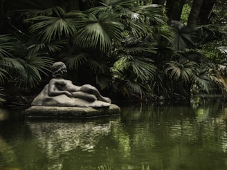 A pond with a statue in the middle of it