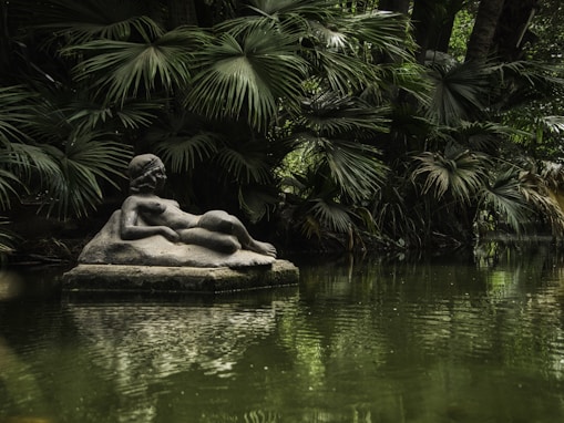 A pond with a statue in the middle of it
