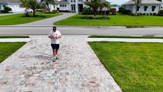 A man running down a sidewalk in a neighborhood
