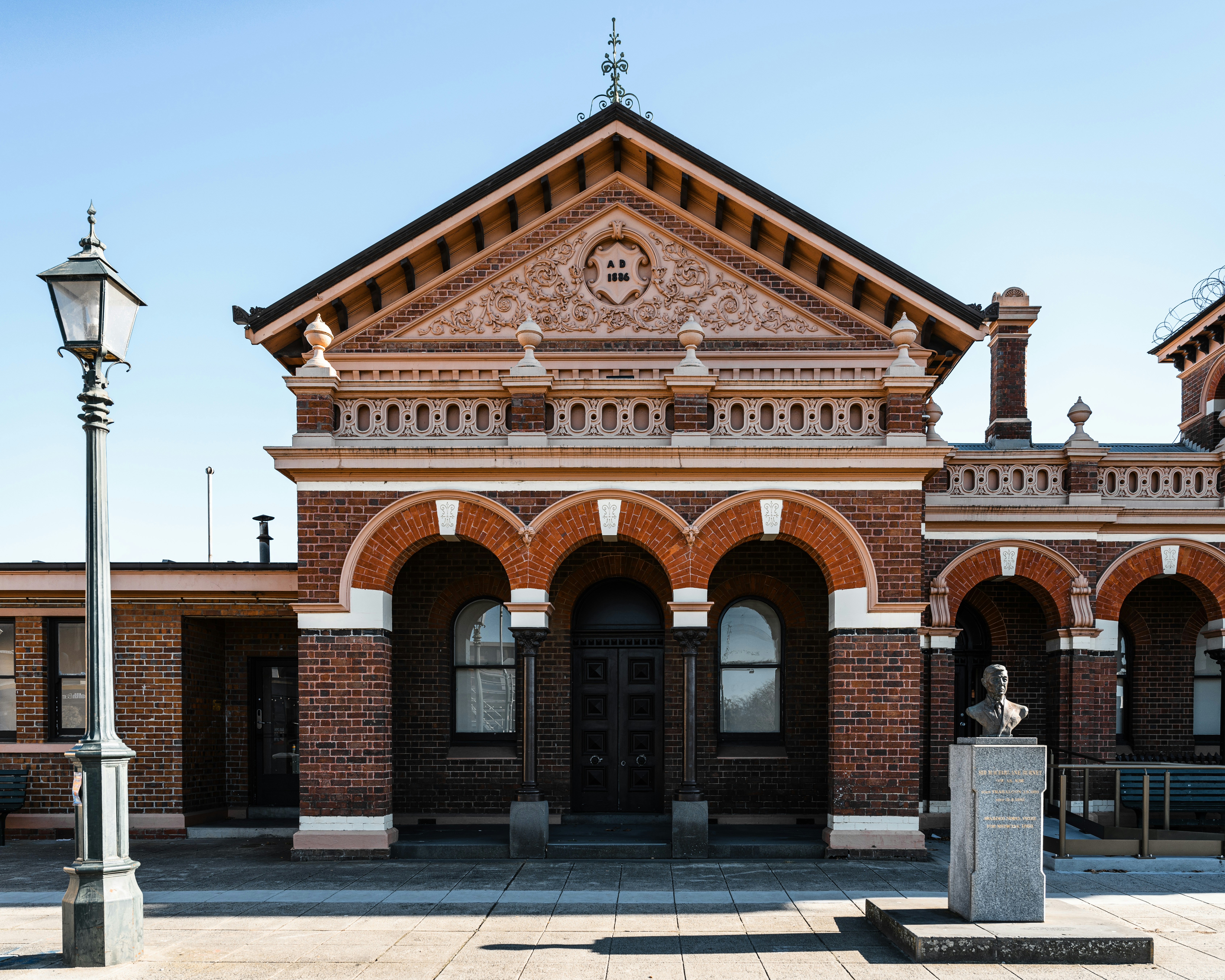 A large brick building with a statue in front of it