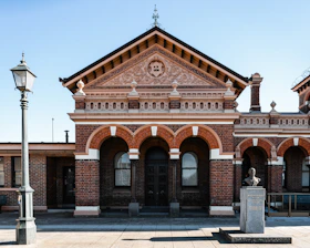 A large brick building with a statue in front of it