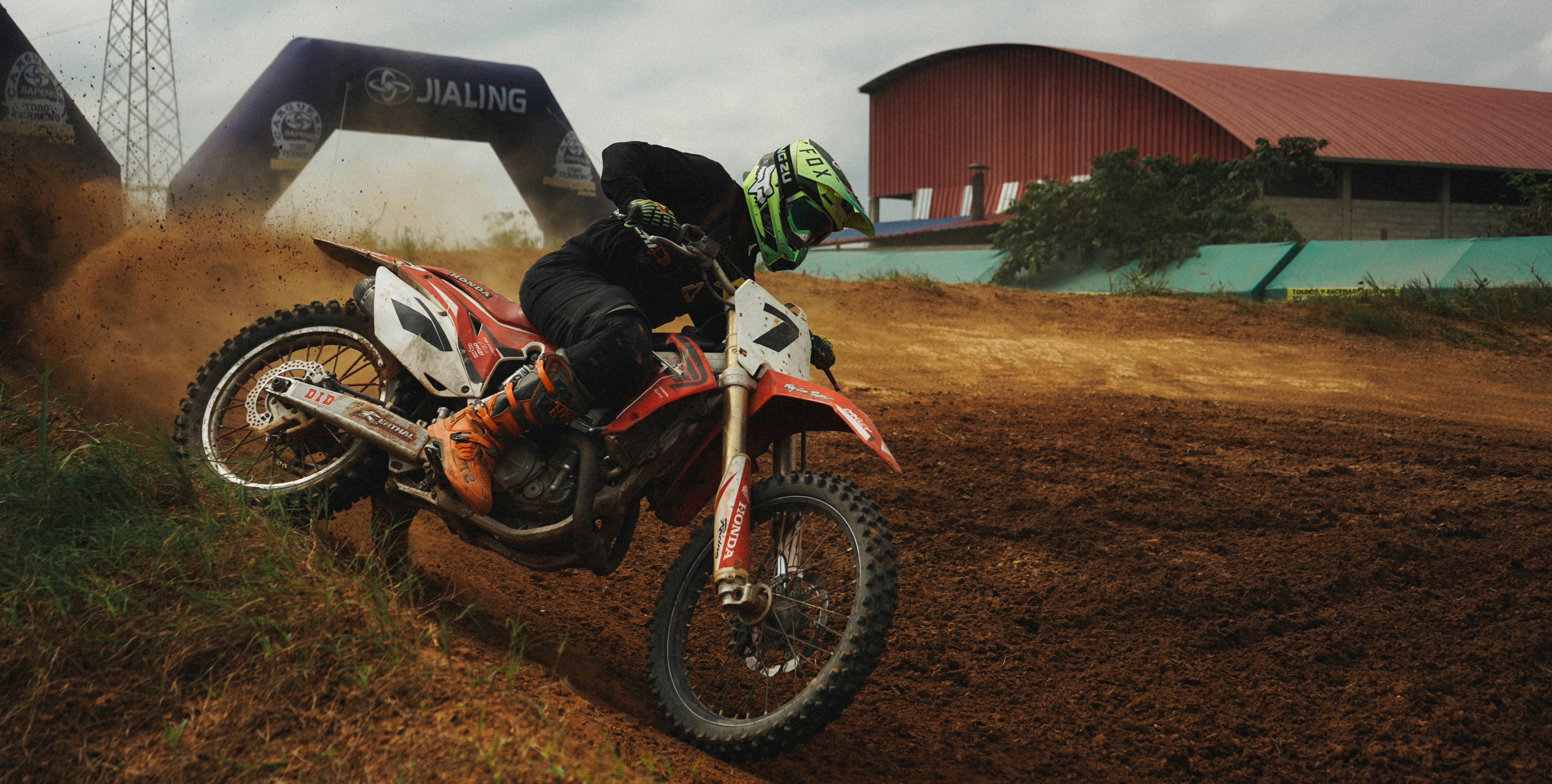 Un uomo in sella a una moto da cross in cima a un campo sterrato