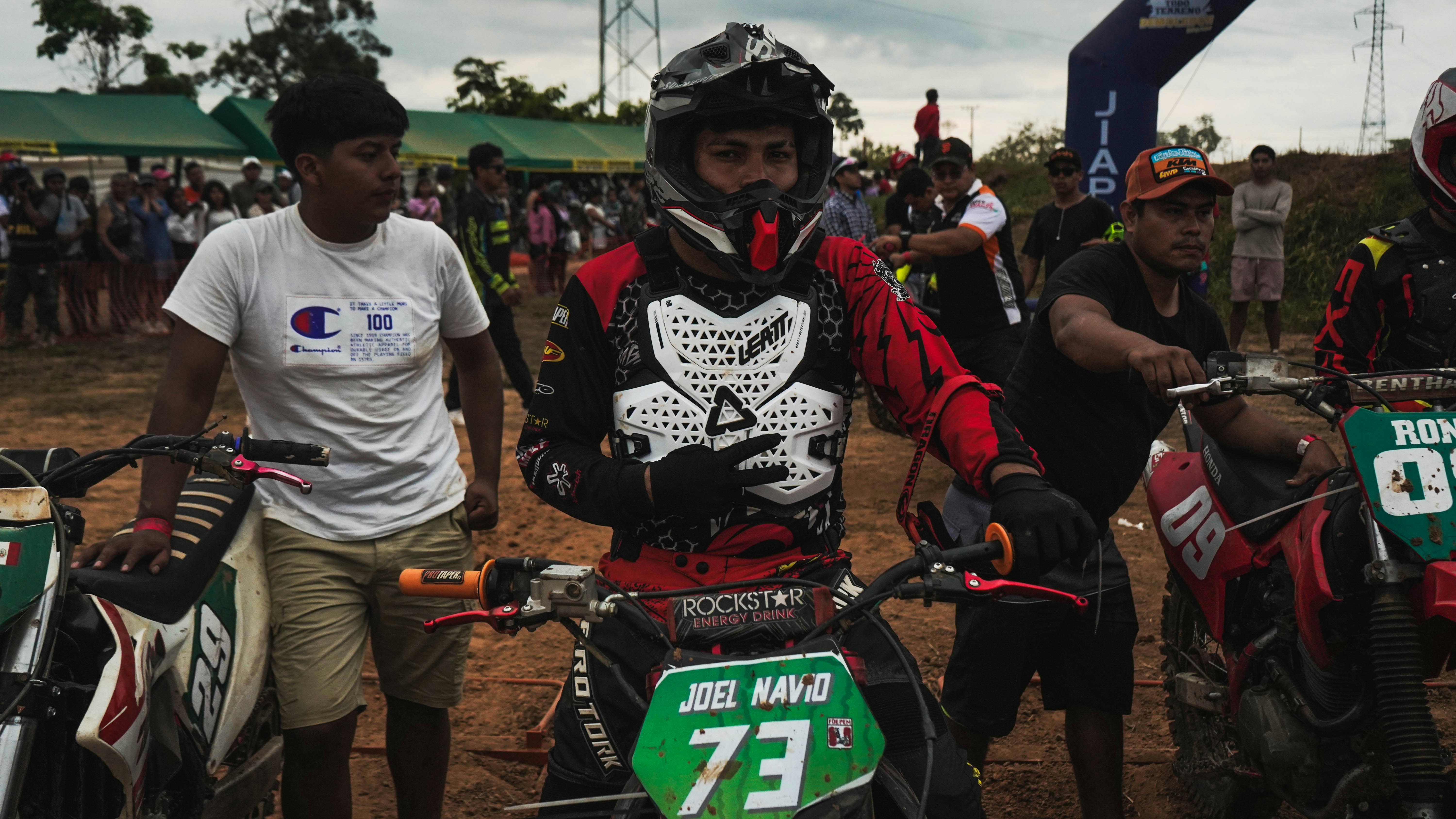 Sekelompok pria berdiri bersebelahan dengan sepeda motor trail