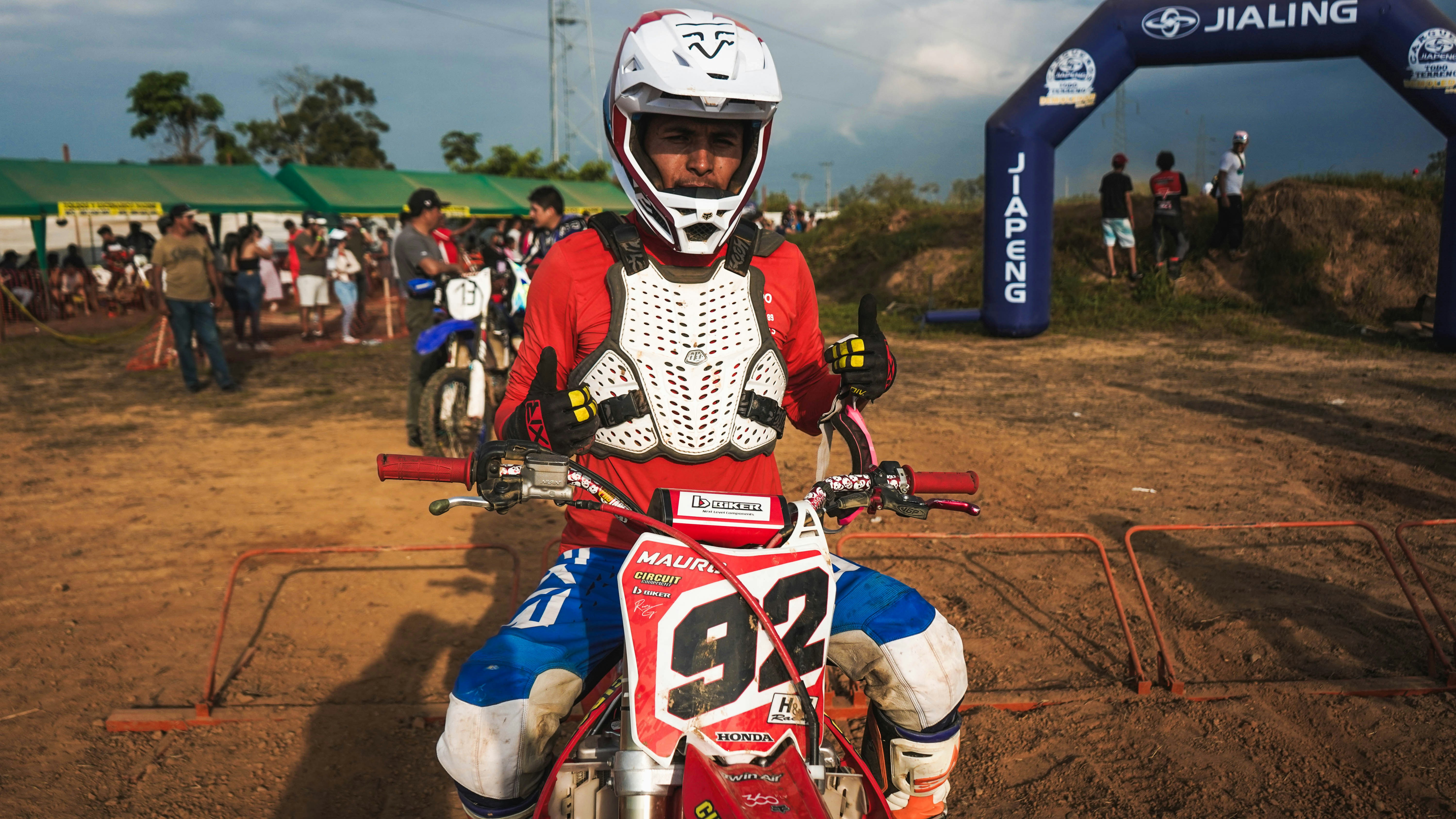 A man riding a dirt bike on top of a dirt field