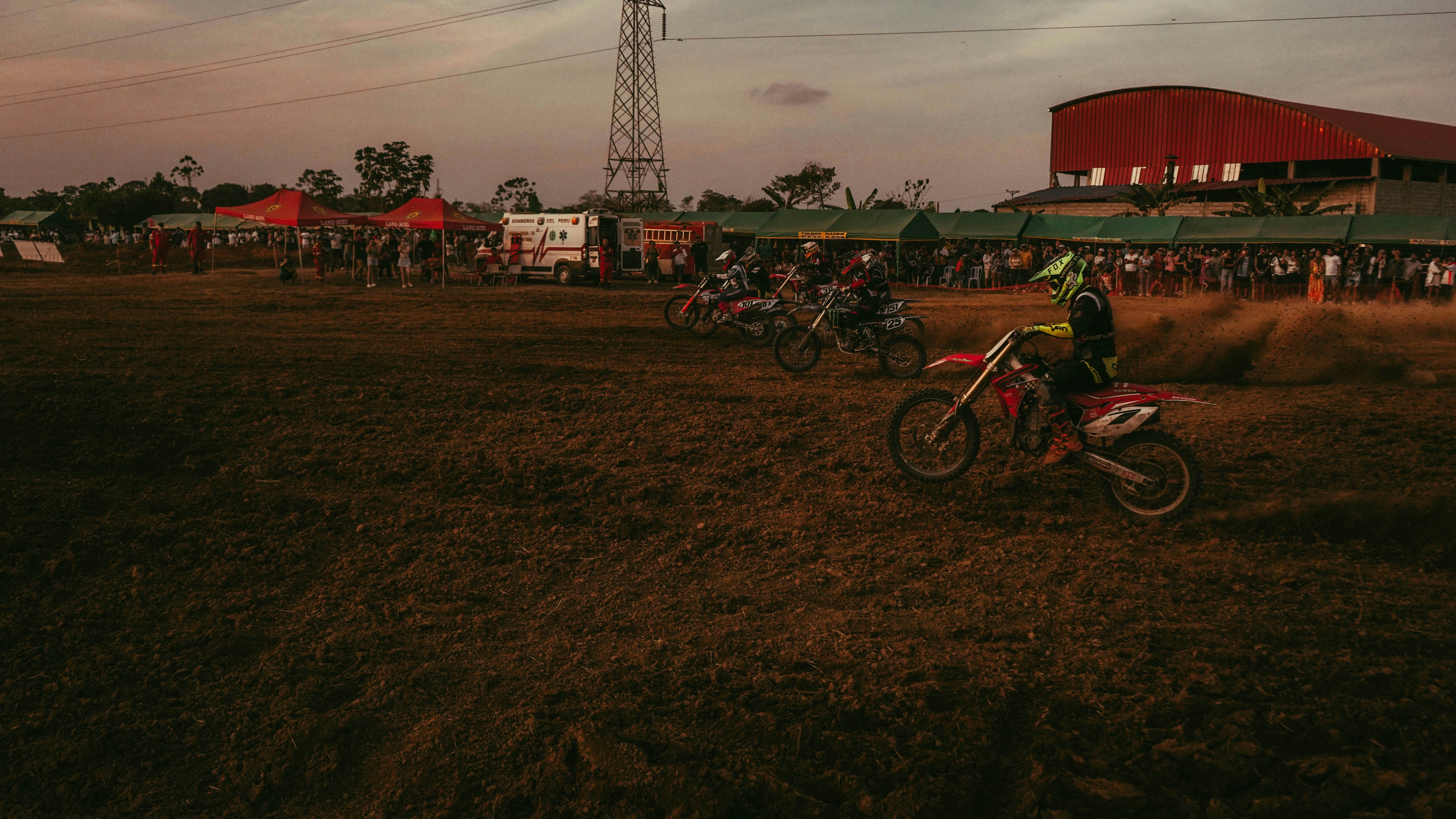 Seorang pria mengendarai sepeda motor trail di atas lapangan tanah