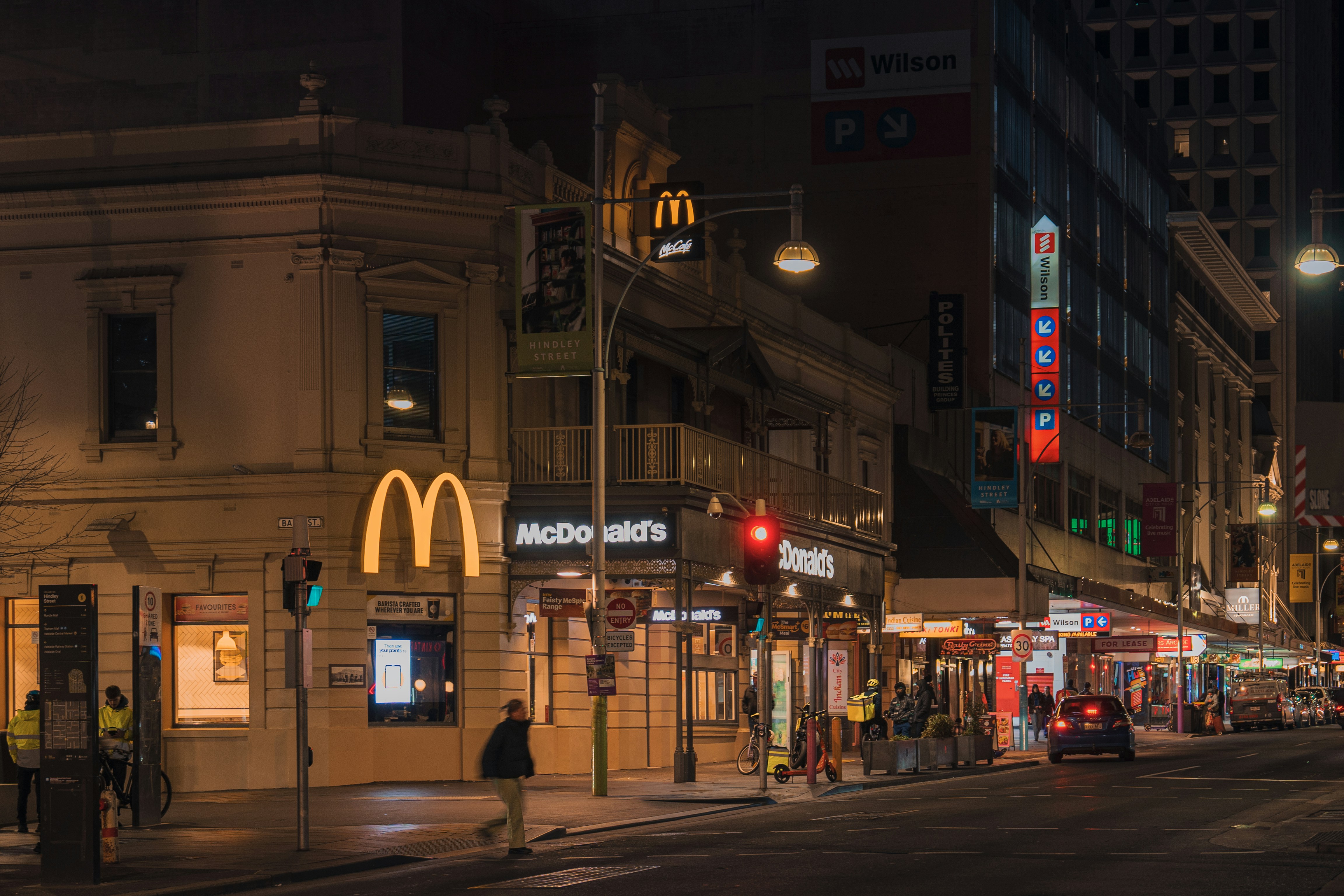 A city street at night with a mcdonald's sign
