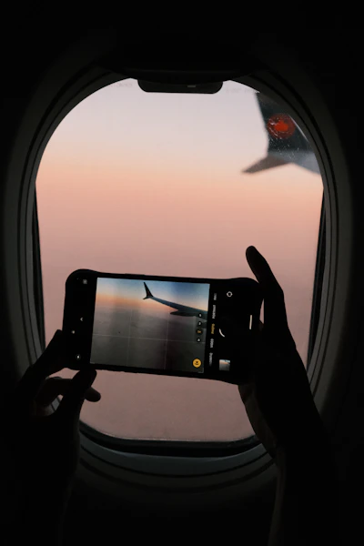 A person taking a picture of an airplane window