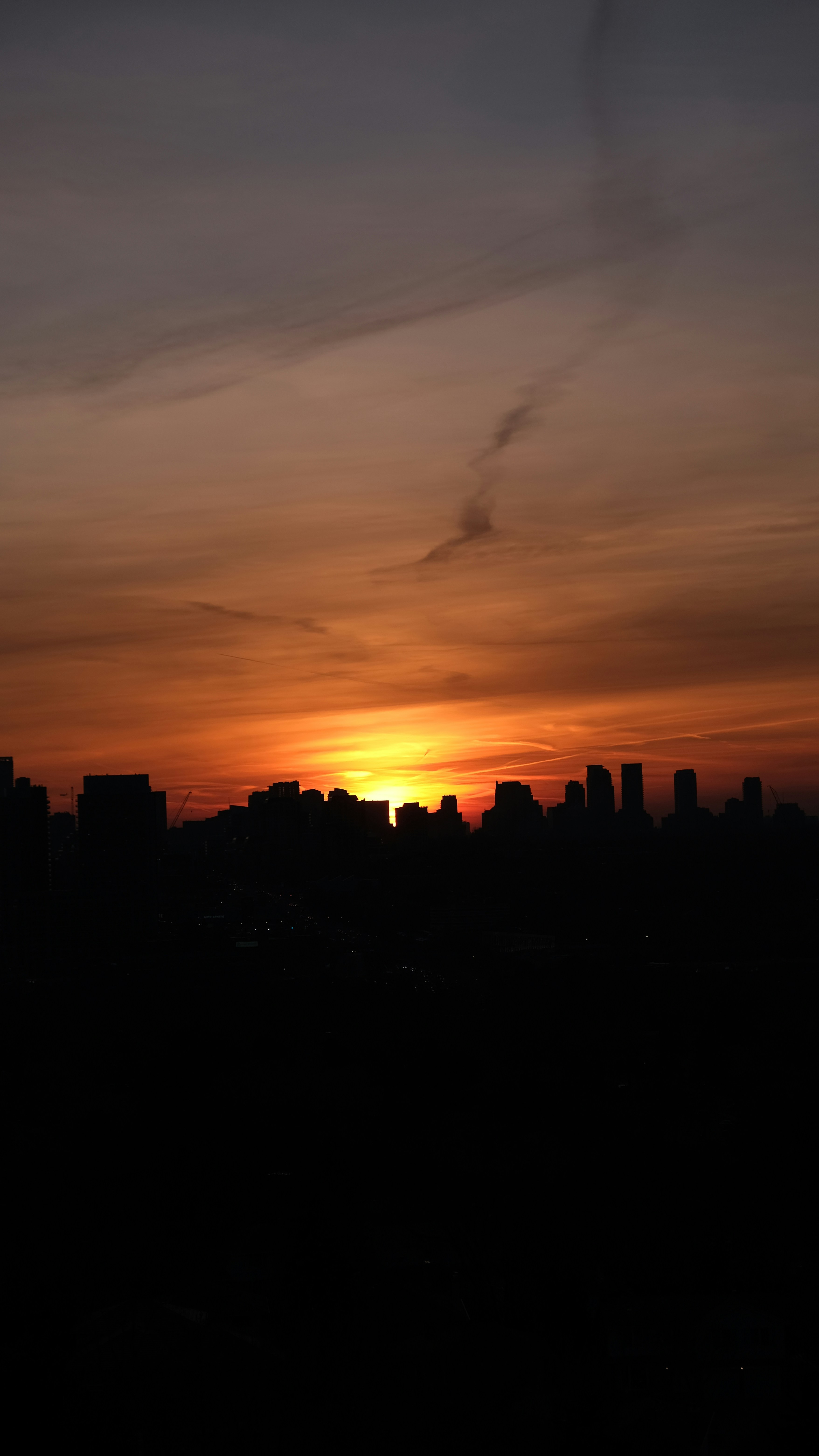 太陽が街のスカイラインに沈む