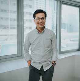 A man standing in front of a window smiling