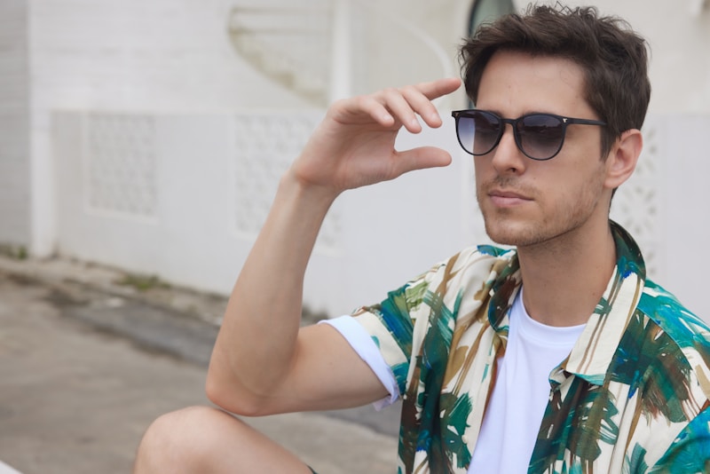 A man sitting on the ground wearing sunglasses