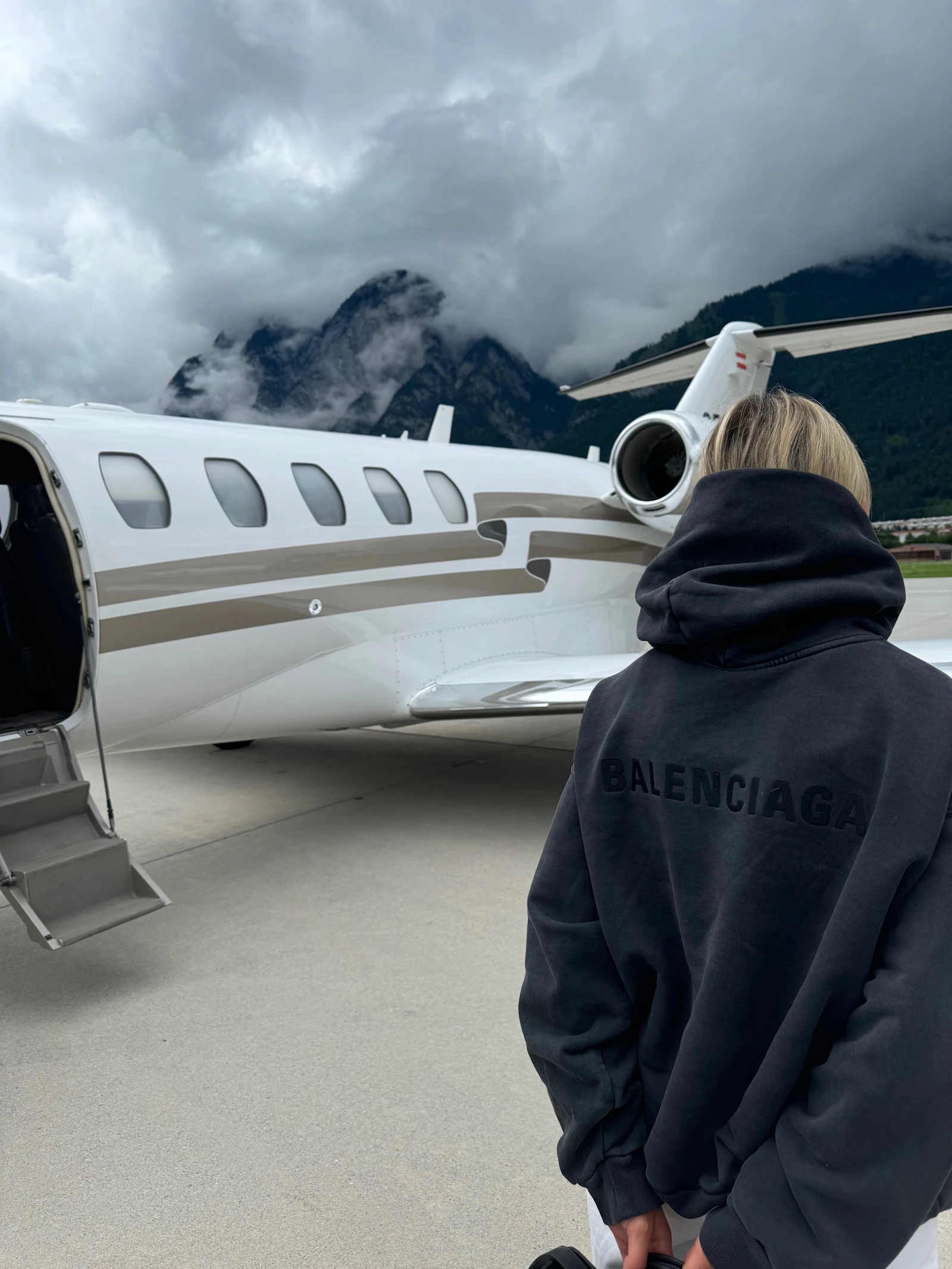 Passenger standing in front of a private jet
