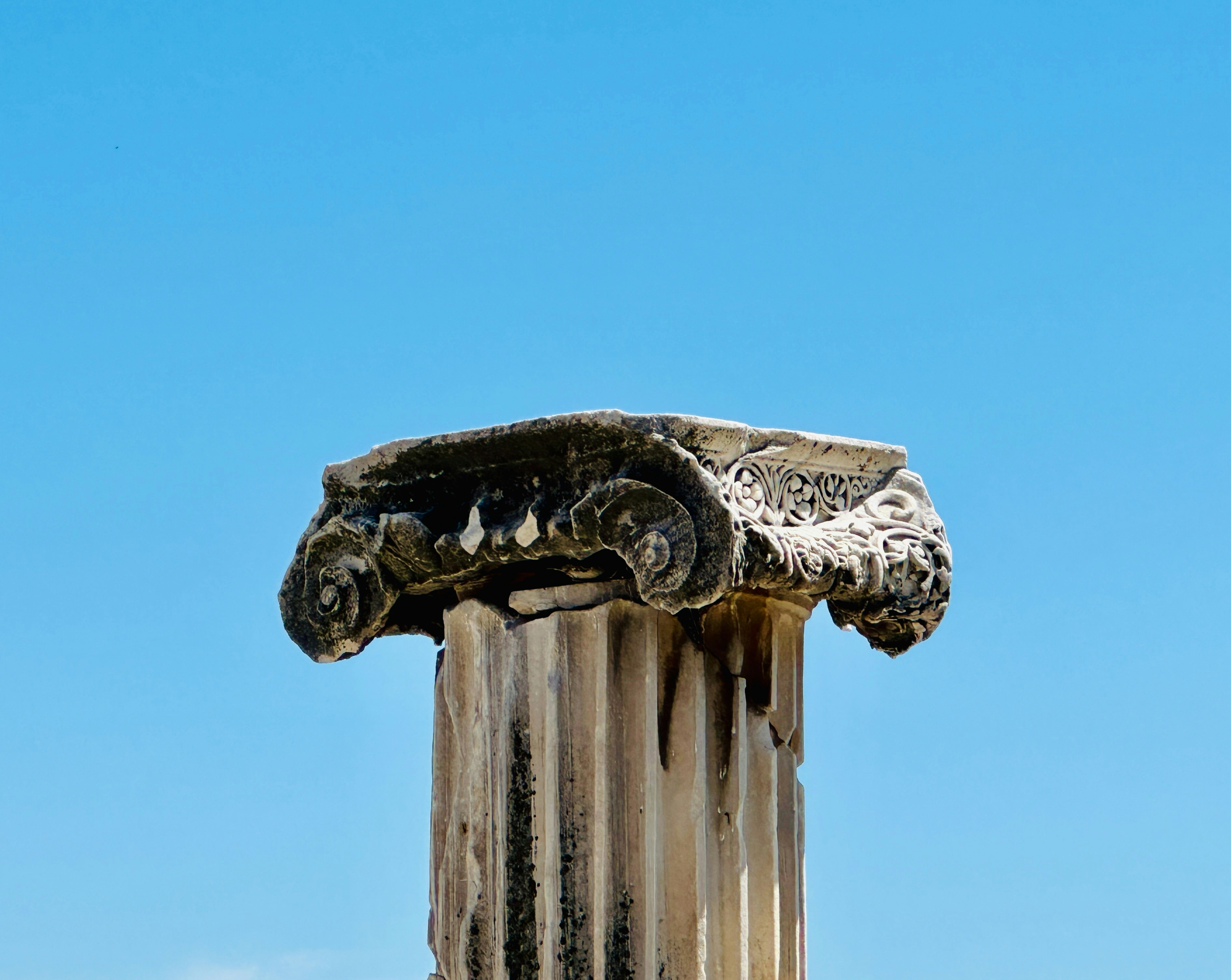 A close up of a column with a sky in the background