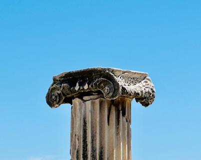 A close up of a column with a sky in the background