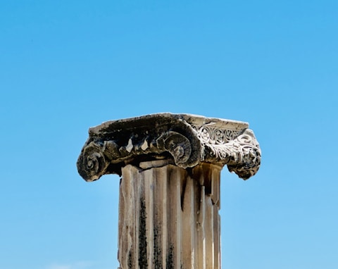 A close up of a column with a sky in the background