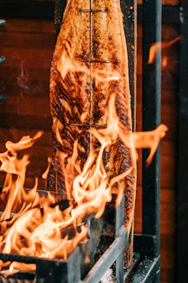 A large piece of meat cooking on a grill