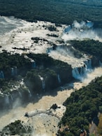 An aerial view of a waterfall in the middle of a forest