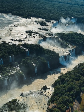 An aerial view of a waterfall in the middle of a forest