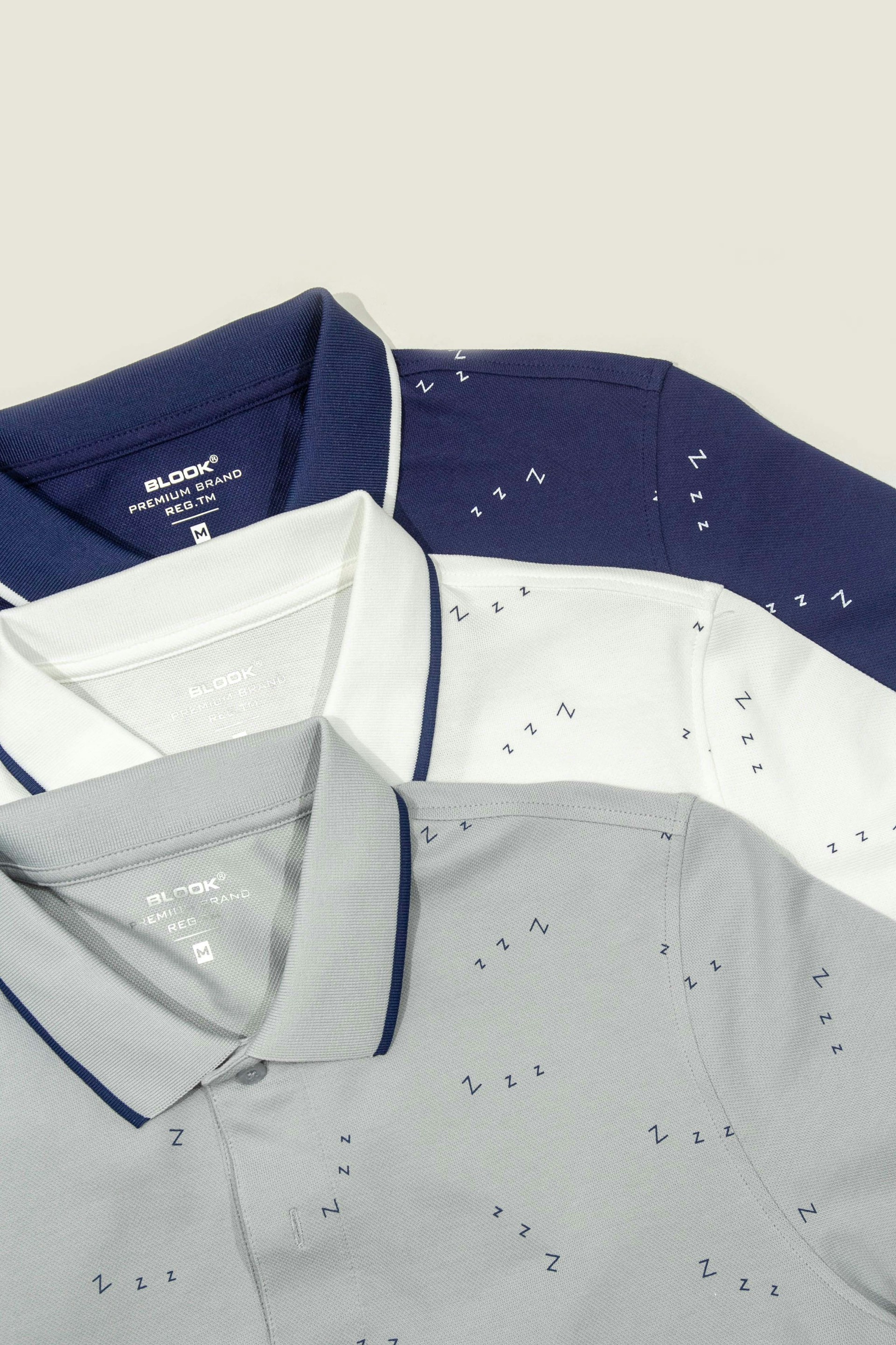 Three men's polo shirts on a white background