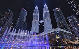 A large fountain in the middle of a city at night