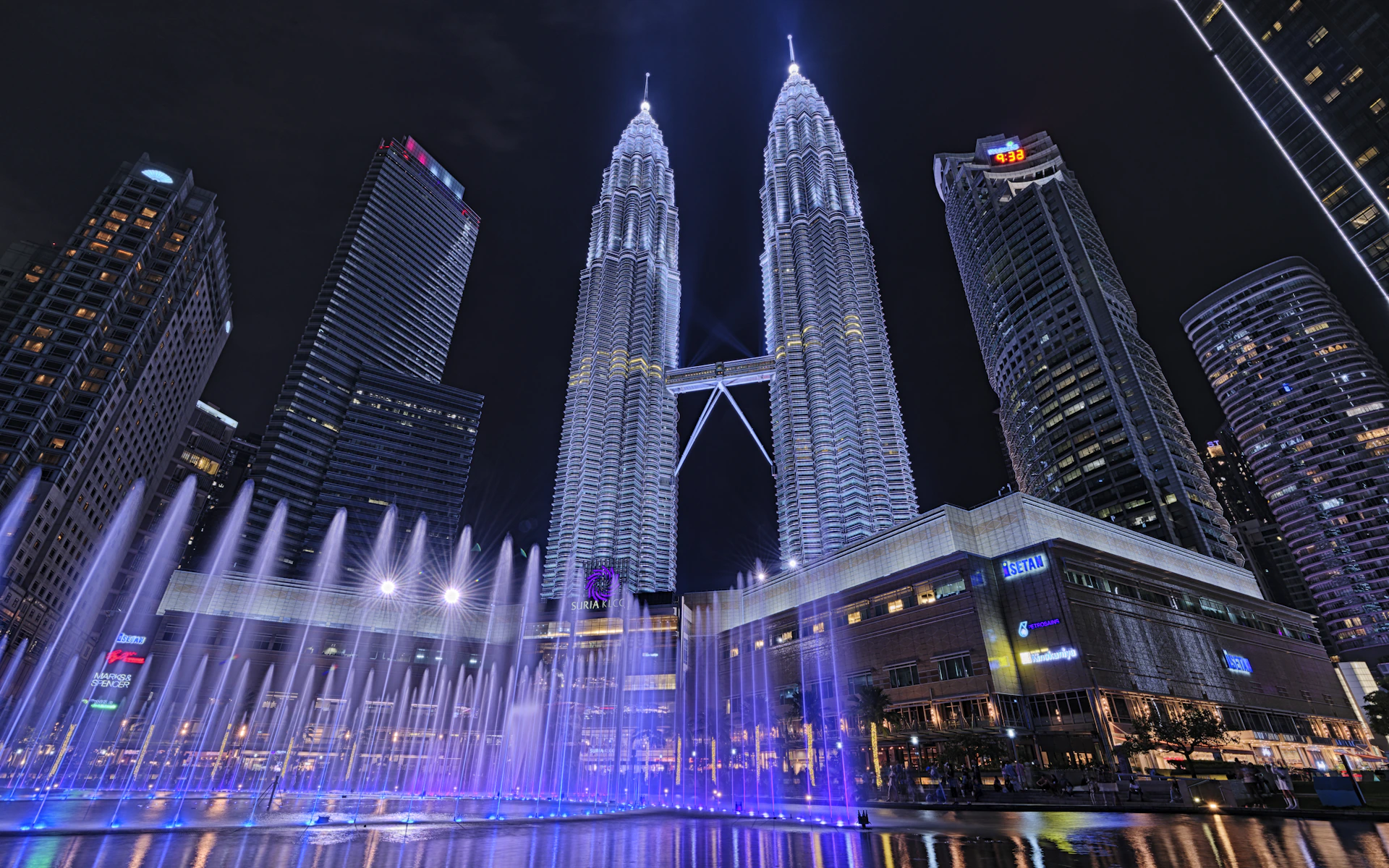 A large fountain in the middle of a city at night