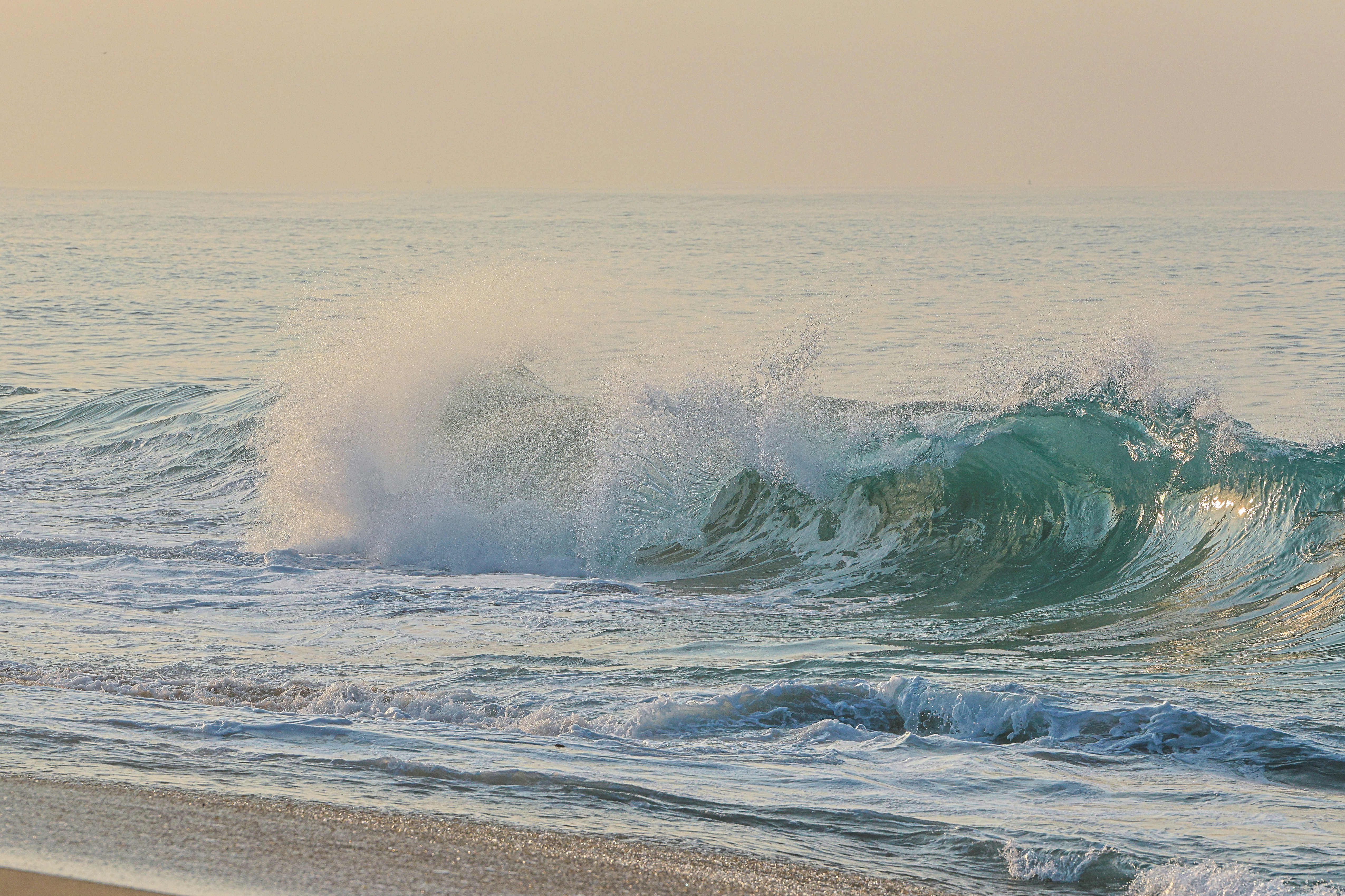 A person walking on the beach with a surfboard