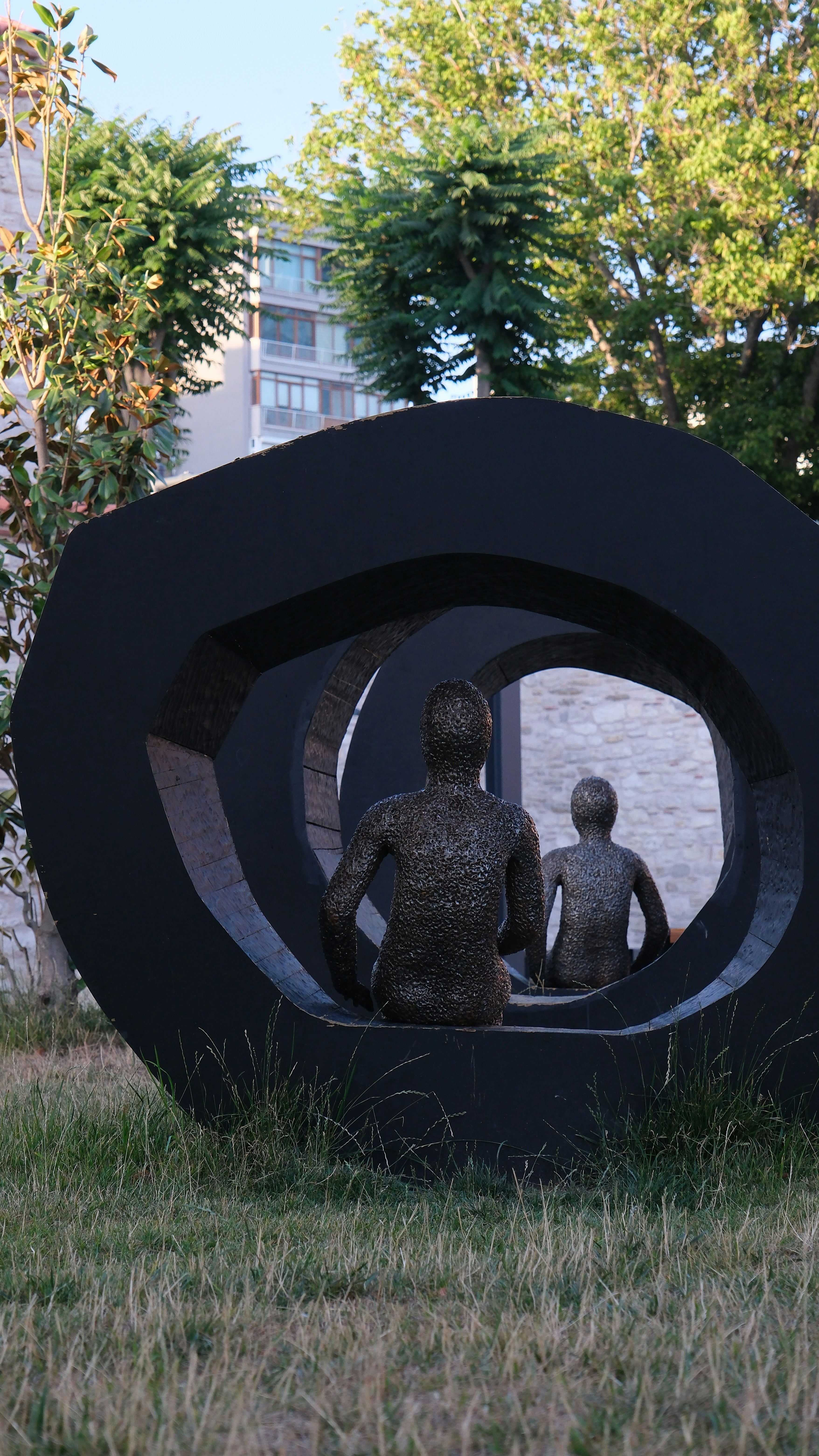 A sculpture of two people sitting on a bench