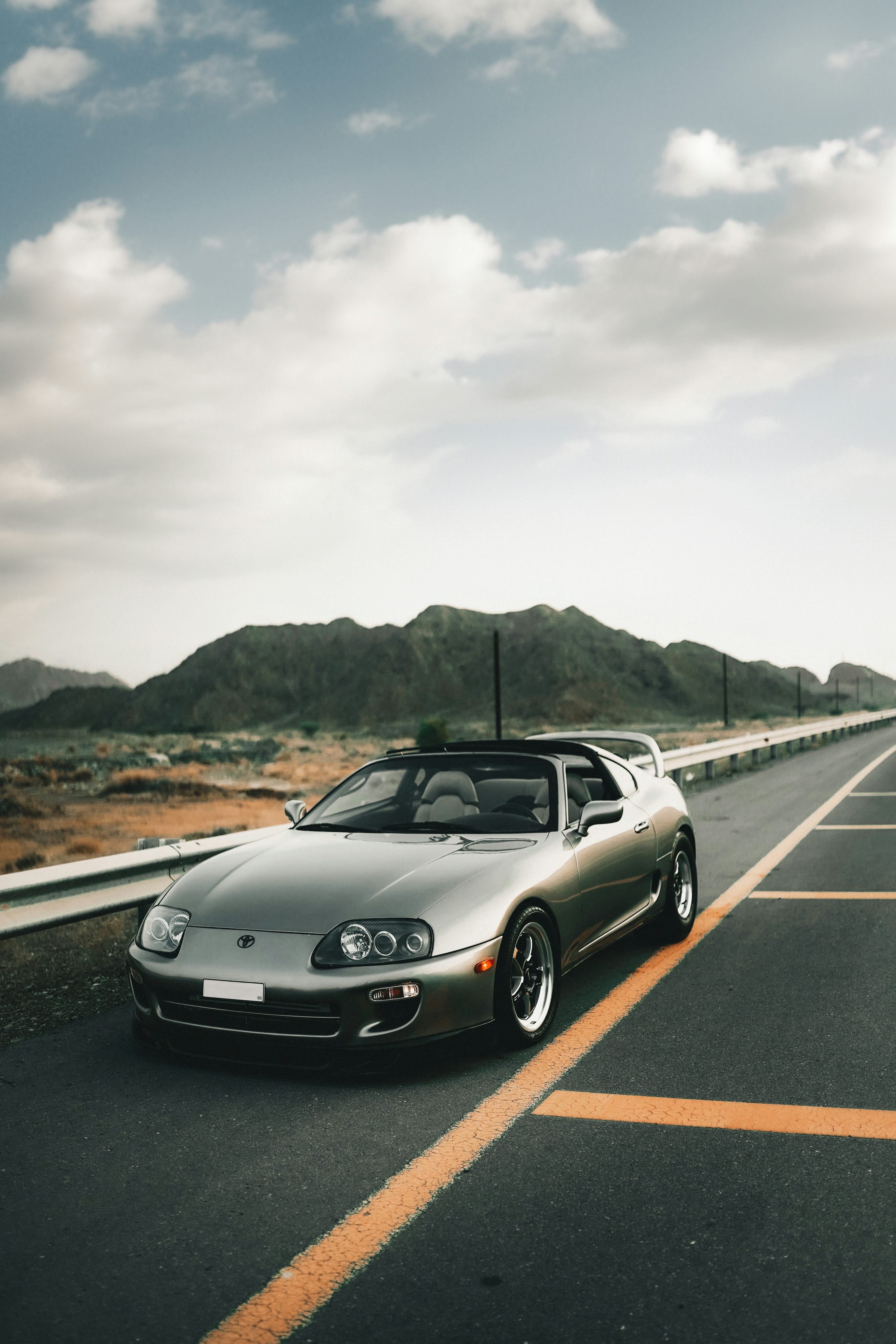A silver sports car parked on the side of the road