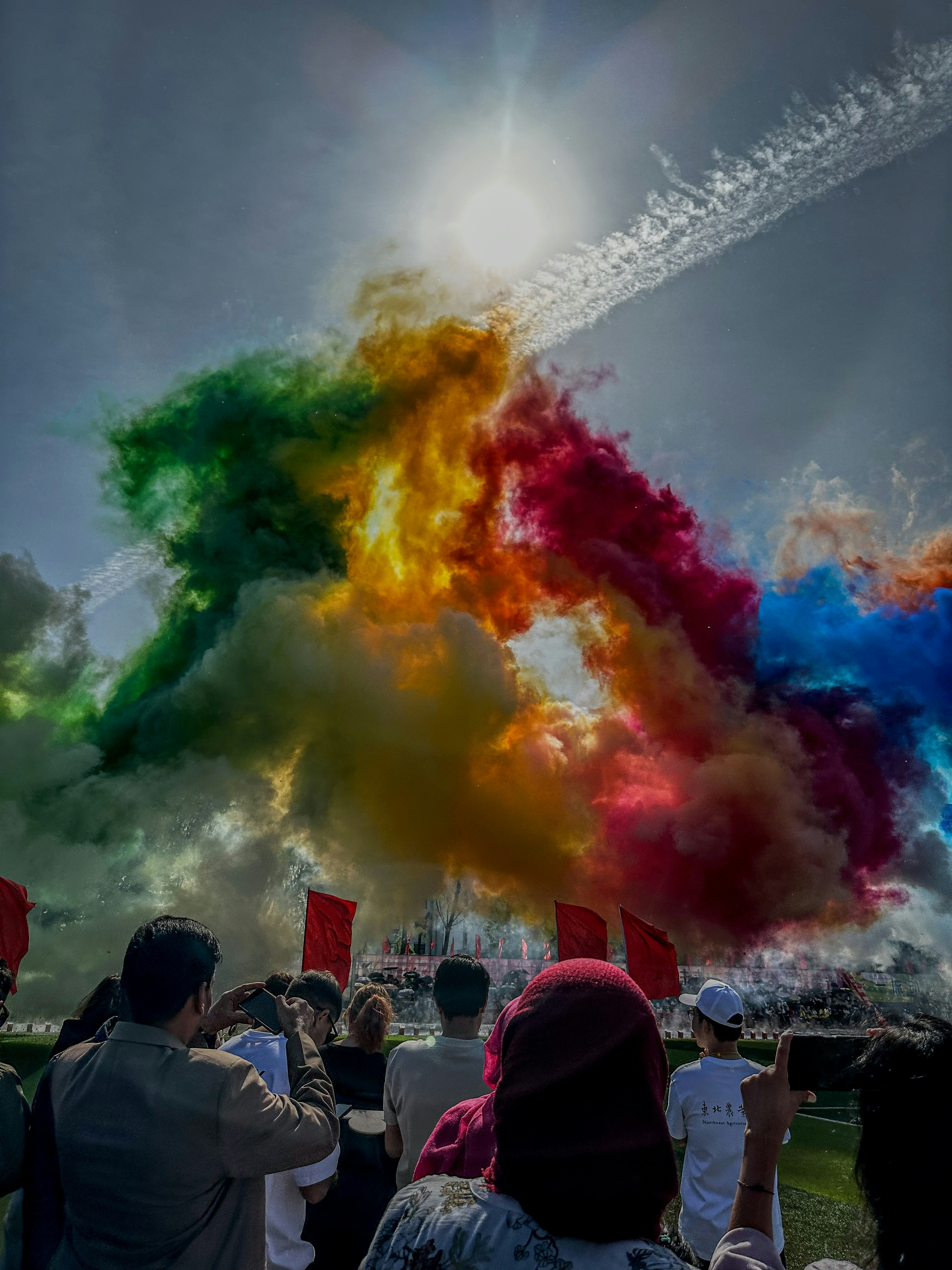 A group of people standing in front of a colorful cloud of smoke