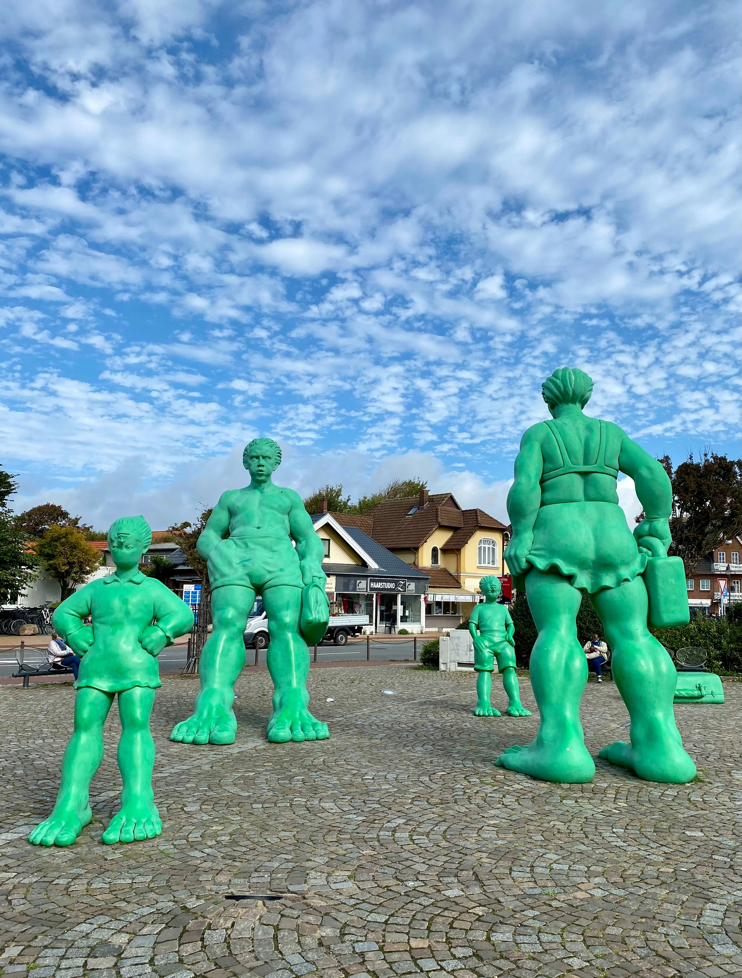 Un groupe de statues vertes d’hommes et de femmes