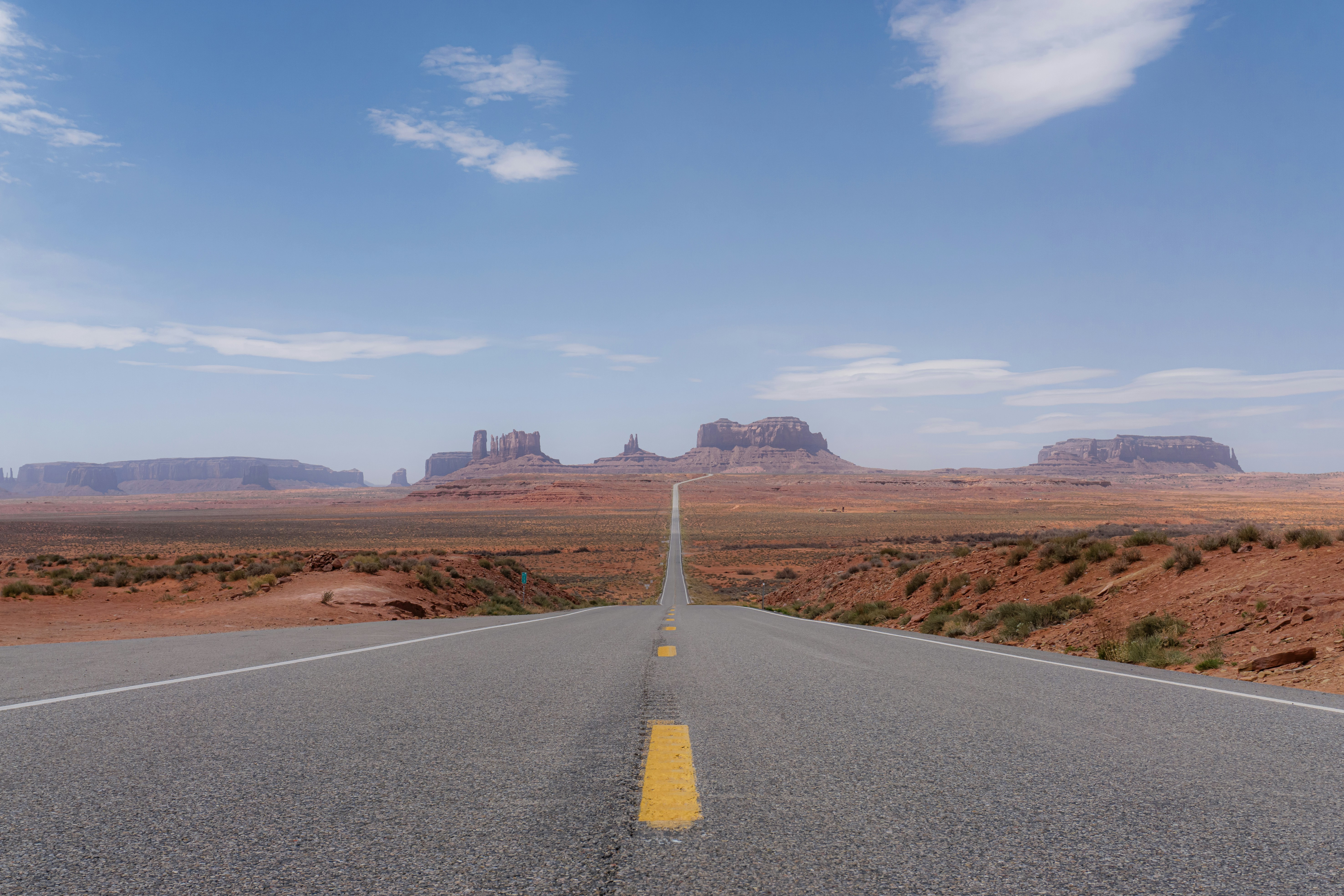 A long road with a yellow line on the middle of it