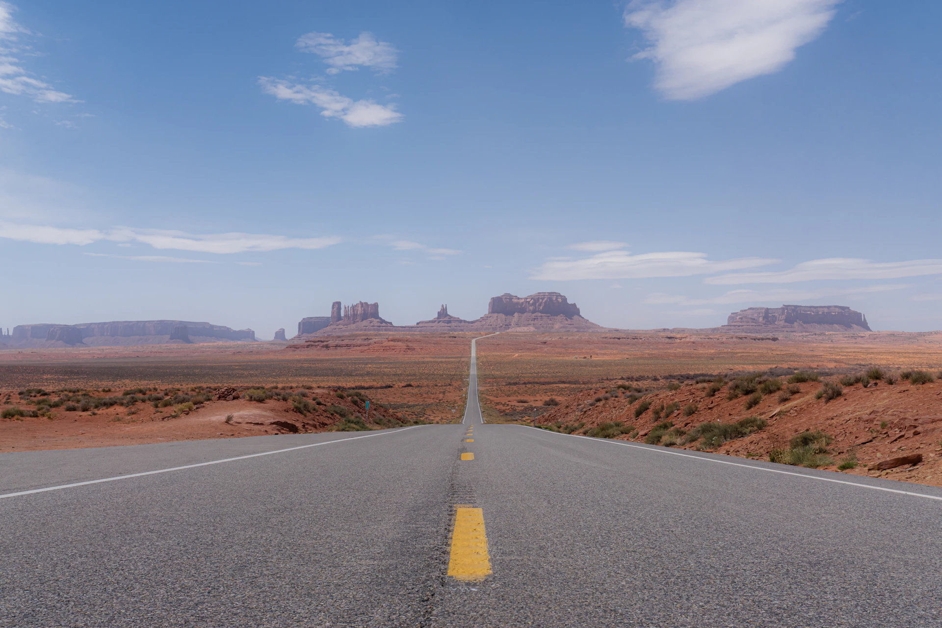 A long road with a yellow line on the middle of it