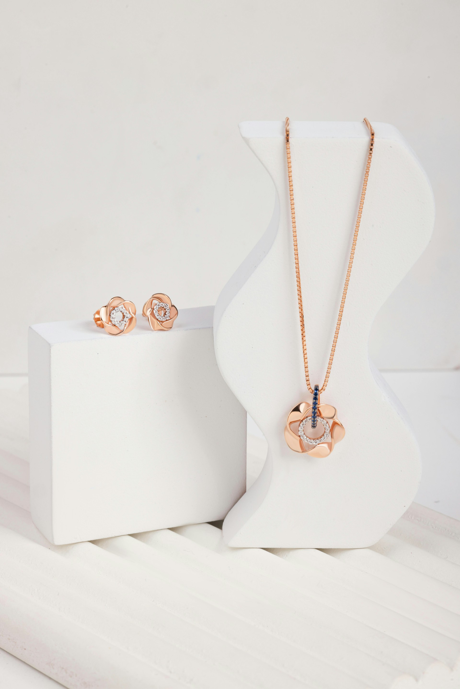 A pair of earrings and a necklace on display