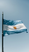 The flag of argentina is flying high in the sky